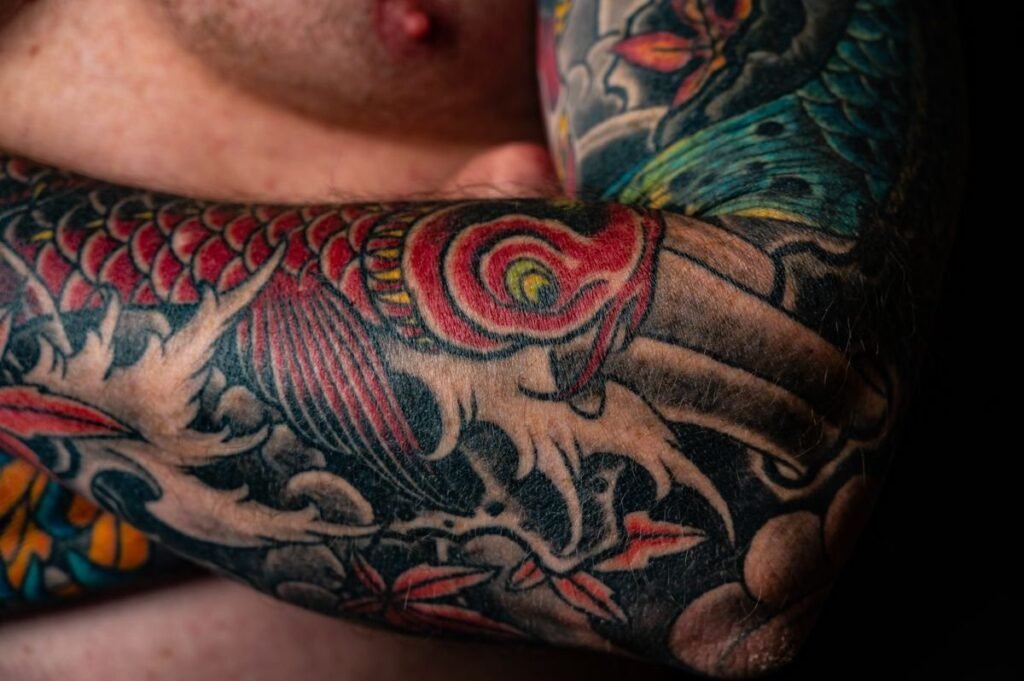Japanse tattoo sleeve in kleur met een koikarper over de hele bovenarm
