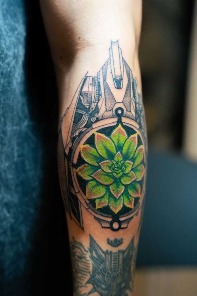 Geometrische mandalatattoo met een groene bloem in het midden op een onderbeen